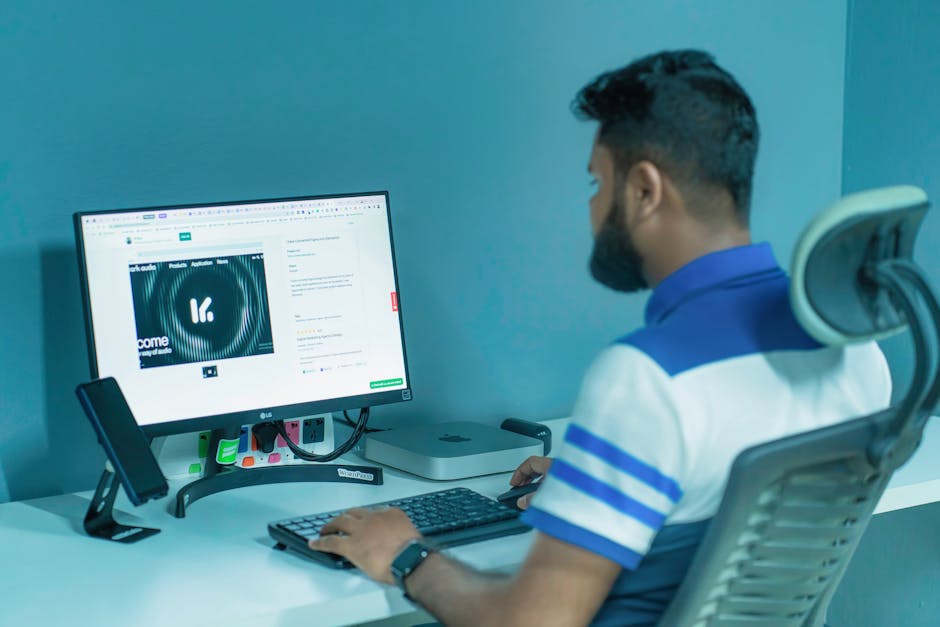 Man using a desktop computer with modern tech setup